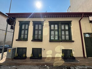 Um edifício com três janelas, uma porta e uma placa.
