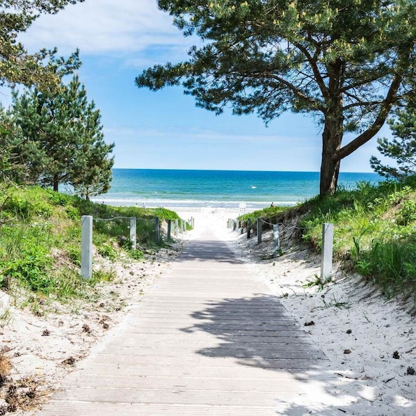 A wooden pathway leading to a beach with a clear view of the ocean. - Müller Vacation Rental (Zirkow)