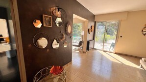 A spacious hallway with a dark wall, various mirrors, and a glass table with a decorative item. - Grand French Family Holiday Home (Saint-Germain-sur-Bresle)