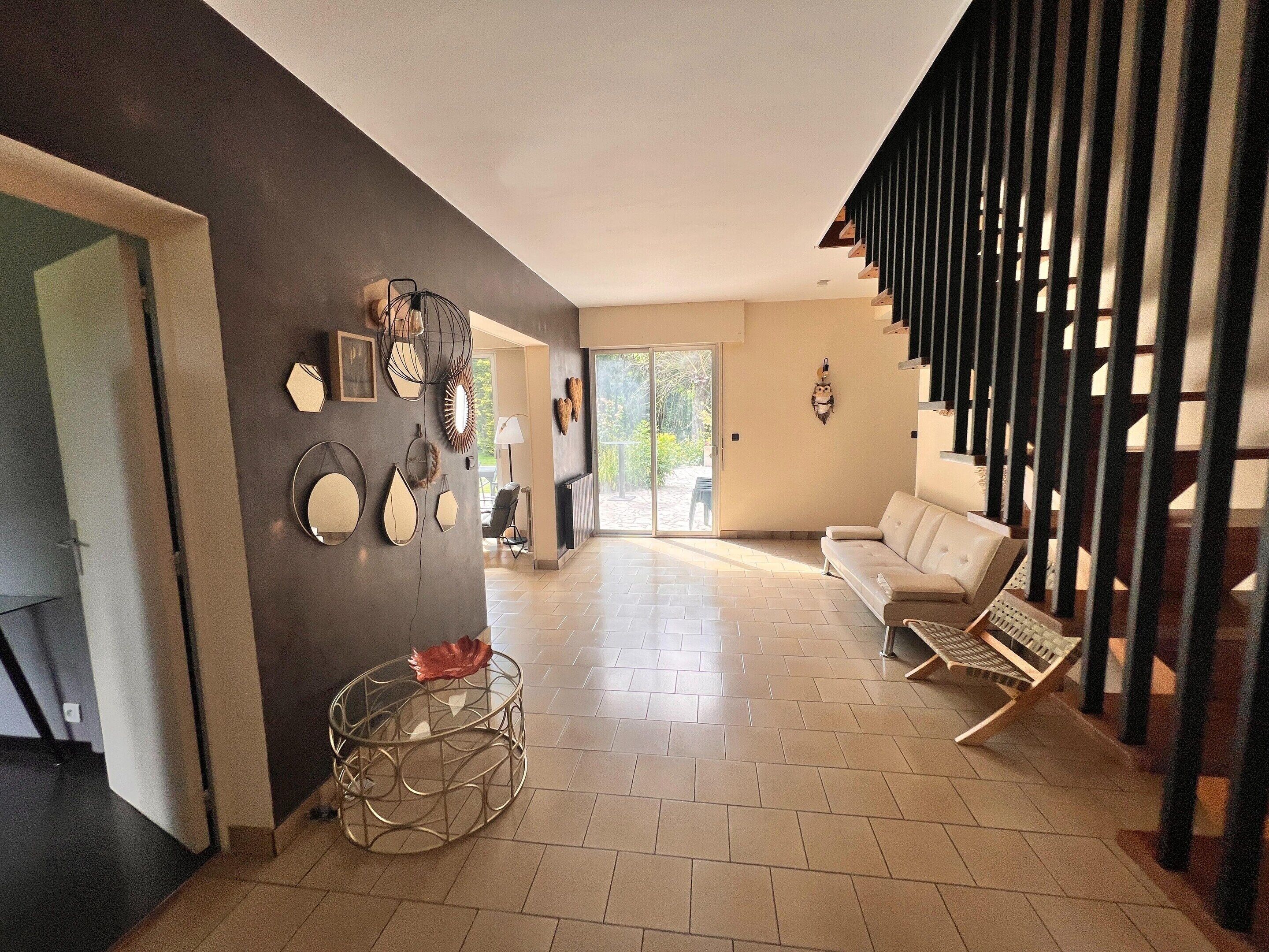 A modern living room with a sofa, a coffee table, and a staircase.