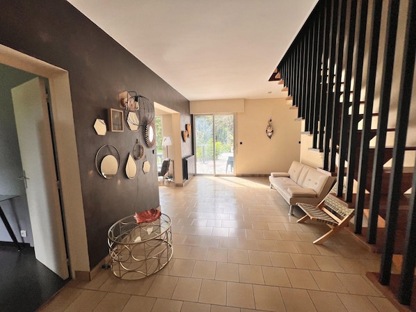 A modern living room with a sofa, a coffee table, and a staircase. - Grand French Family Holiday Home (Saint-Germain-sur-Bresle)