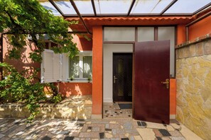 A building with a tiled entrance, a door, and a window with shutters. - Eco friendly holiday home with pool (Pula)