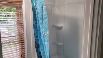 Een douche, handdoeken, zeep, toiletpapier
