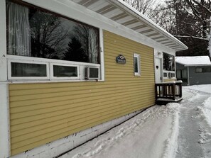 A yellow building with a large window, a small porch, and a sign that reads 'HIGHLINE'.