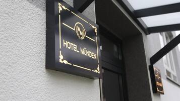 Une enseigne noire avec des lettres dorées indiquant « HÔTEL MÜNDEN ».