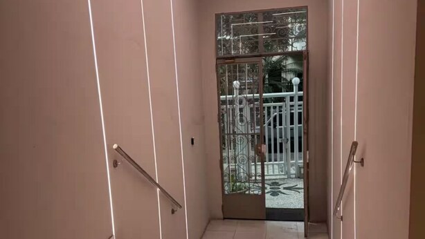 Ein modernes Interieur mit Marmorboden, einer Glastür mit Metallgeländern und eingelassener Beleuchtung.