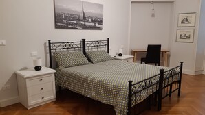 A bedroom with a bed, bedside tables, a desk, and a chair. - Vacation in Turin, just a few minutes from downtown in a lively, multicultural neighborhood (Torino)