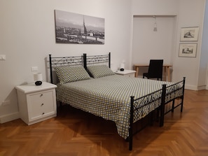 Ein Schlafzimmer mit Bett, Nachttischen, Schreibtisch und Stuhl.