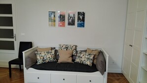 A bedroom with a bed, a chair, and three posters on the wall. - Vacation in Turin, just a few minutes from downtown in a lively, multicultural neighborhood (Torino)