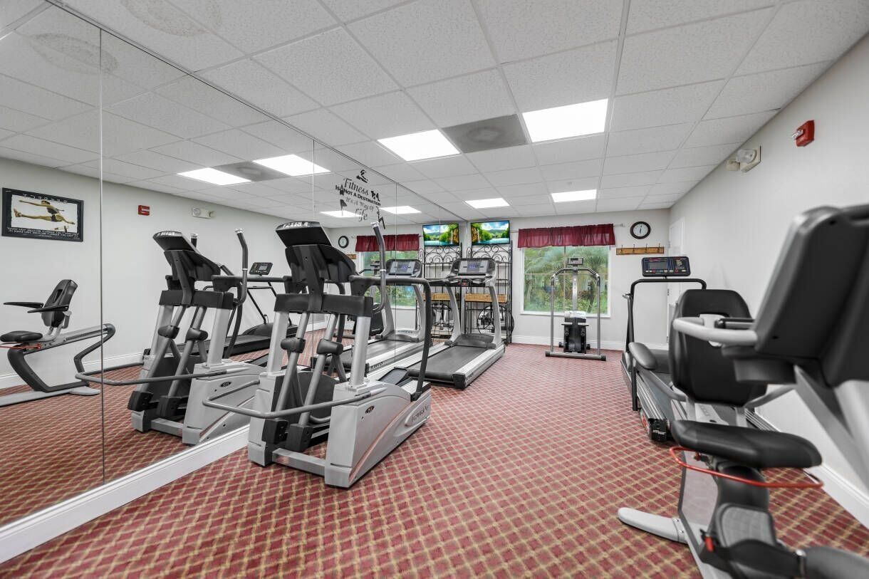 Et fitnesscenter med løbebånd, crosstrainere og styrkeudstyr.
