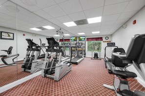 Ein Fitnessstudio mit Laufbändern, Crosstrainern und Gewichten.