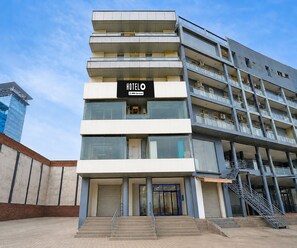 Ein mehrstöckiges Hotel mit modernem Design, das ein auffälliges 'HOTEL'-Schild über dem Eingang zeigt.