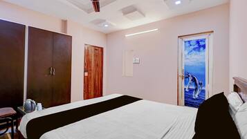 Une chambre d’hôtel avec un lit, une armoire et une porte ornée d’une fresque représentant des dauphins.