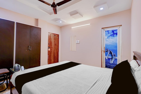 A hotel room with a bed, wardrobe, and a door with a dolphin mural.