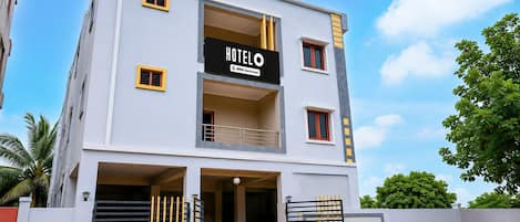 Un hotel de dos pisos con un cartel que indica que es administrado por OYO.