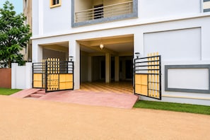 Un moderno edificio de dos pisos con una entrada central, un balcón en el nivel superior y un piso con diseño de cuadros en su interior.