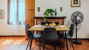 Comedor con mesa de madera preparada para cuatro personas, rodeada de sillas.