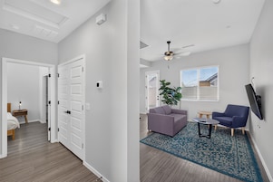 Una sala de estar moderna con un sofá, una mesa de centro y un televisor montado en la pared.