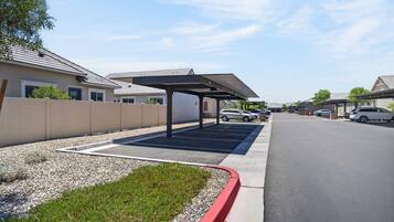 A parking area with covered parking spaces and a clear sky.