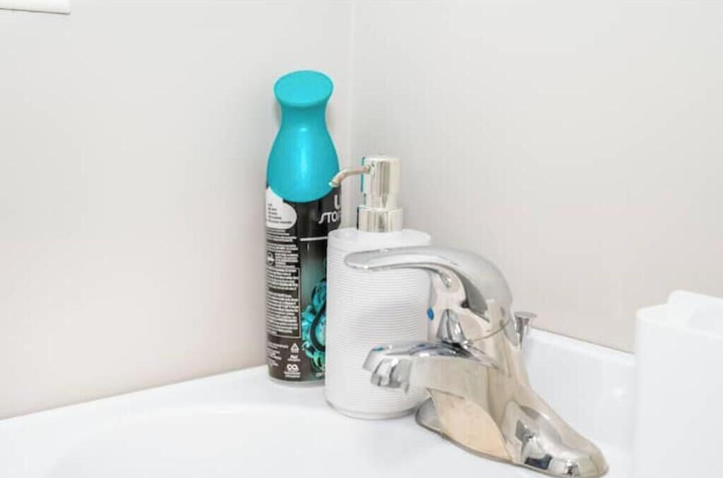 Ein Badezimmer mit einem weißen Waschbecken, einer blauen Flasche und einem weißen Spender.