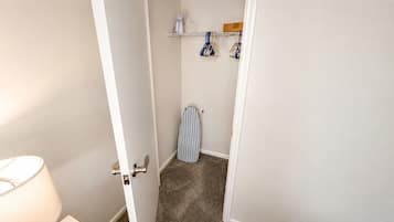 A narrow hallway with a door leading to a room.