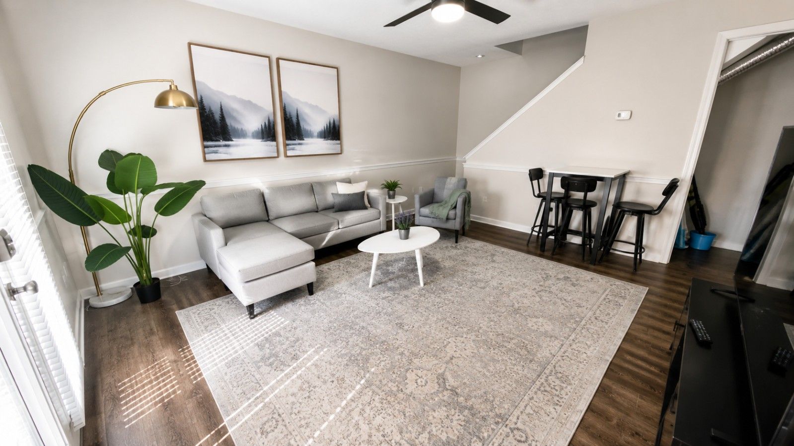 A living room with a sofa, coffee table, and a dining area with chairs.
