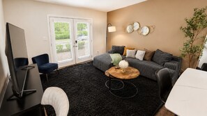 A living room with a sofa, a coffee table, a TV, and a plant.