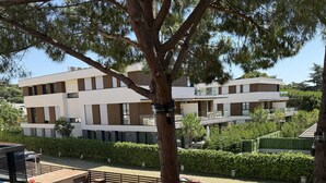 A modern building with a flat roof, large windows, and a well-maintained lawn. - Duplex apartment 800 meters from the beach, in a high-end residential complex, in a quiet area (Castell d'Aro)