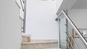 A staircase with a handrail, a painting above, and a small framed picture below. - Duplex apartment 800 meters from the beach, in a high-end residential complex, in a quiet area (Castell d'Aro)