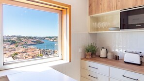 Eine moderne Küche mit Blick auf eine Stadtlandschaft durch ein großes Fenster.