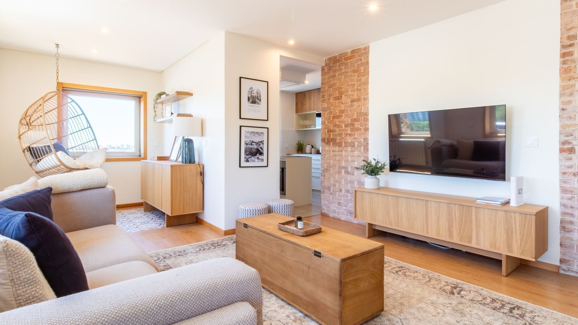 Un salon moderne avec un canapé, une table basse, un téléviseur et un mur décoratif en briques.