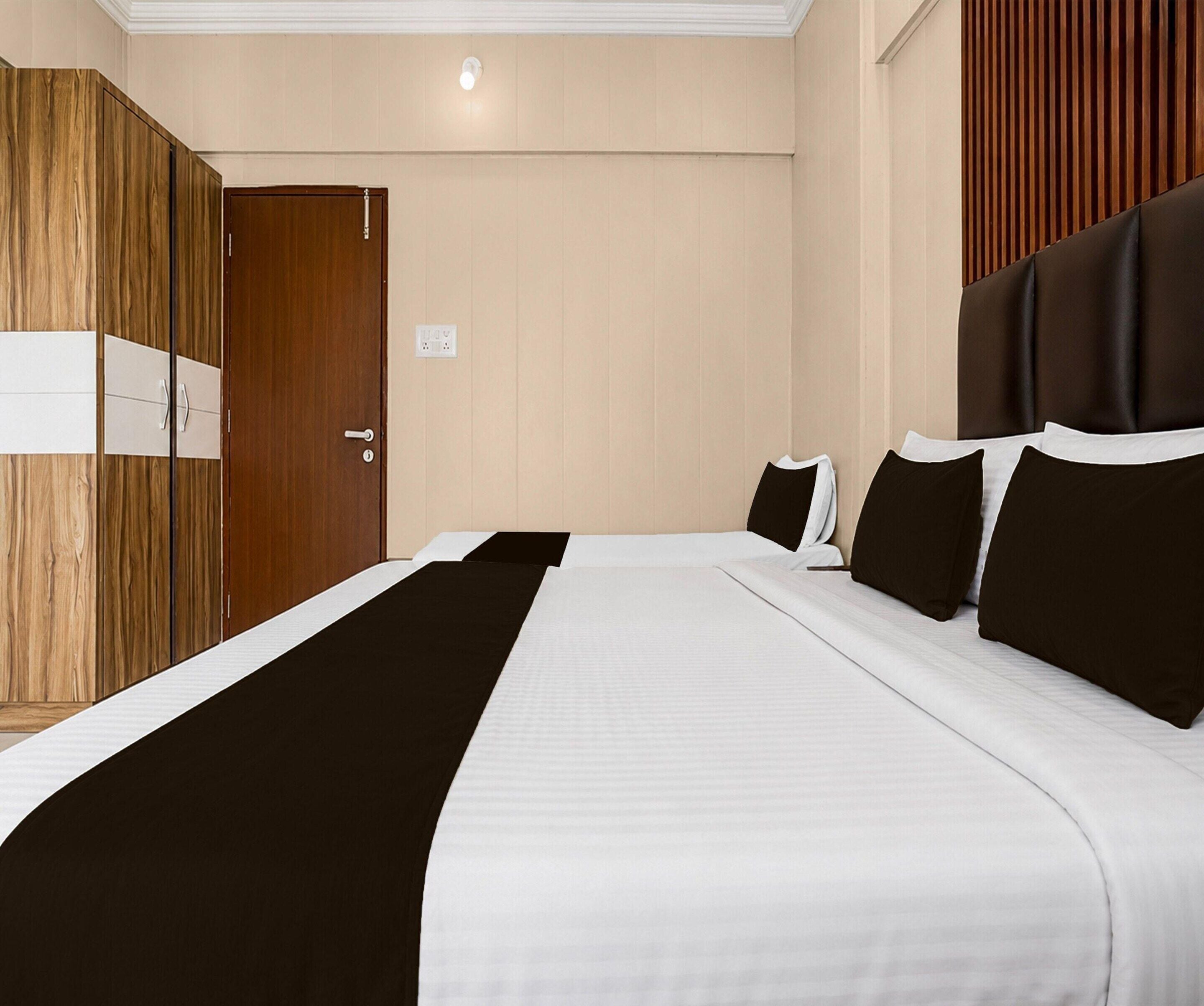 Una habitación de hotel con cama, armario e iluminación en la pared.