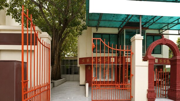 Una entrada cerrada con una reja metálica y un arco decorativo.