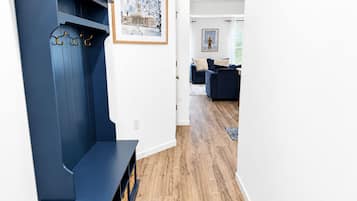 Una sala de estar moderna con un banco azul oscuro, un cuadro enmarcado en la pared y suelo de madera.