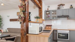 A kitchen with a microwave, oven, and grey cabinets. - Sea View Villa in Jesenice with Jacuzzi (Jesenice)