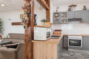 Eine Küche mit Mikrowelle, Backofen und grauen Schränken.