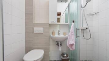 Ein Badezimmer mit Toilette, Waschbecken und Dusche.