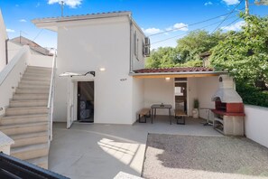 A residential property with a staircase, a patio with a table and chairs, and a barbecue area. - Peaceful Holiday Home Near Baška (Draga Bašćanska)