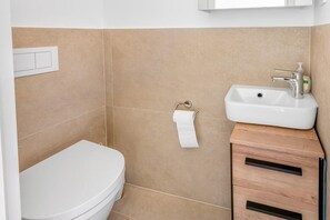 A bathroom with a toilet, sink, and a towel rack. - Peaceful Holiday Home Near Baška (Draga Bašćanska)
