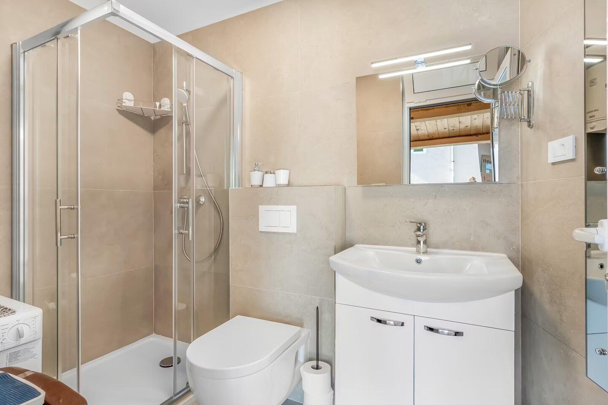 A bathroom with a glass-enclosed shower, a white toilet, a sink with a mirror, and a towel rack.