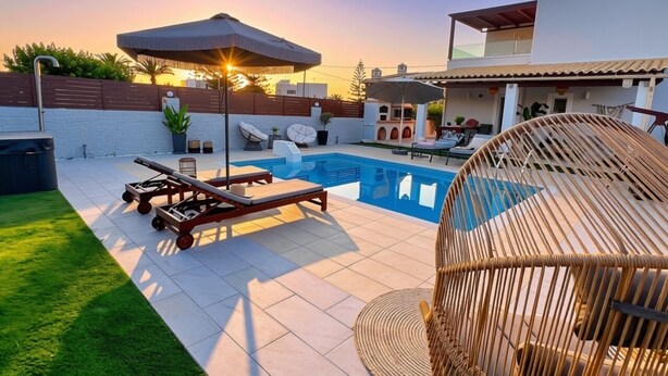 Area piscina sul tetto con sedie a sdraio, una pergola e vista libera sul tramonto.