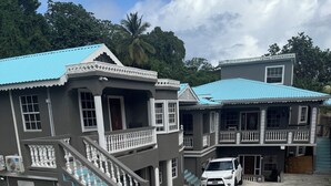 A two-story building with a balcony and a staircase. - Spacious 3-bedroom apartment in adorable Gros Islet with AC near popular spots (Gros Islet)