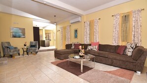 A living room with a sofa, armchairs, a coffee table, and a dining area with chairs and a table. - Spacious 3-bedroom apartment in adorable Gros Islet with AC near popular spots (Gros Islet)
