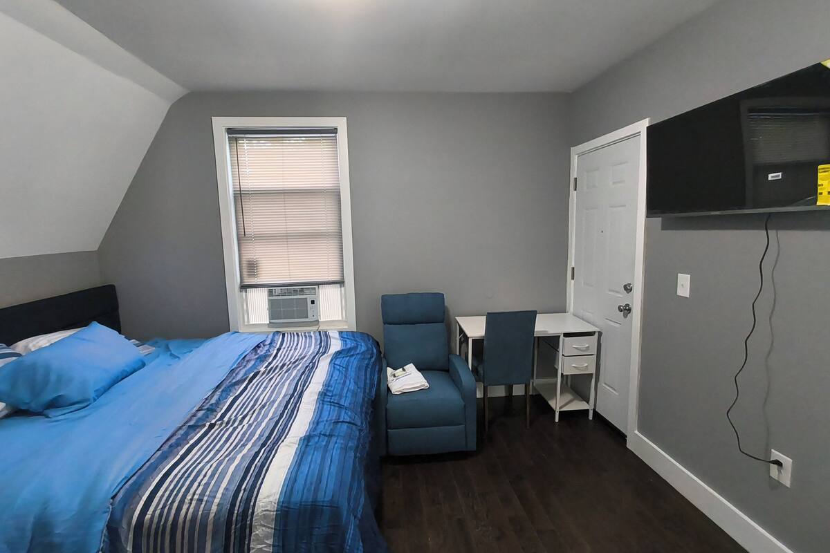 Un dormitorio con cama, escritorio y silla.