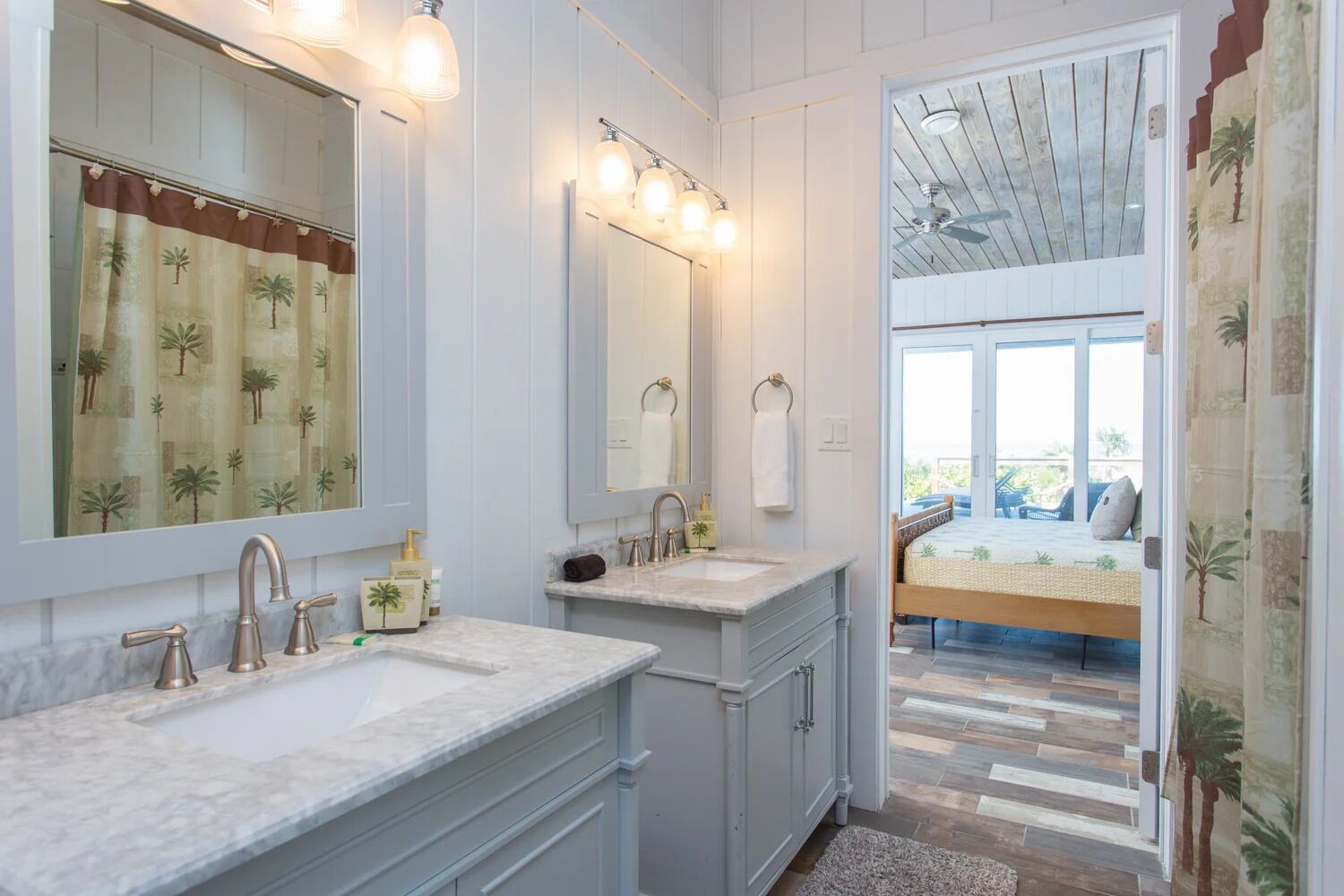 A bathroom with two sinks, a large mirror, and a ceiling fan.