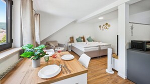 Une chambre d’hôtel moderne dotée d’un coin repas, d’un lit et offrant une vue sur l’extérieur.