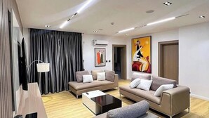 A modern living room with two sofas, a coffee table, and a TV. - 501 Aparthotel (Akure)