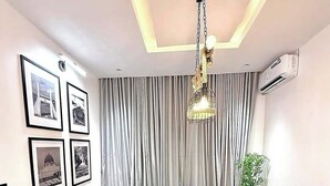A modern conference room with a black table, grey upholstered chairs, a chandelier, and framed pictures on the wall. - 501 Aparthotel (Akure)