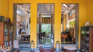 A room with a chessboard, a wooden stool, a bookshelf, and a chair. - CASA DE COLUMNAS (Cartagena)