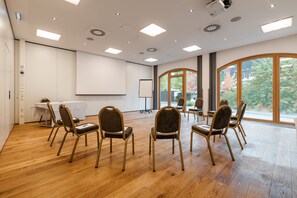A conference room with a whiteboard, projector, and multiple chairs arranged for a meeting.